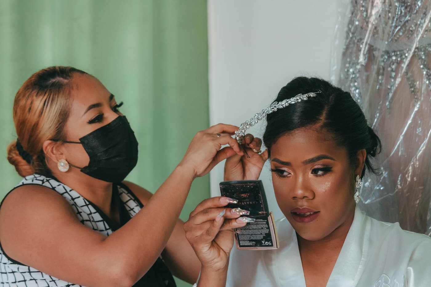 Makeup artist preparing a bride, holding a lash strip